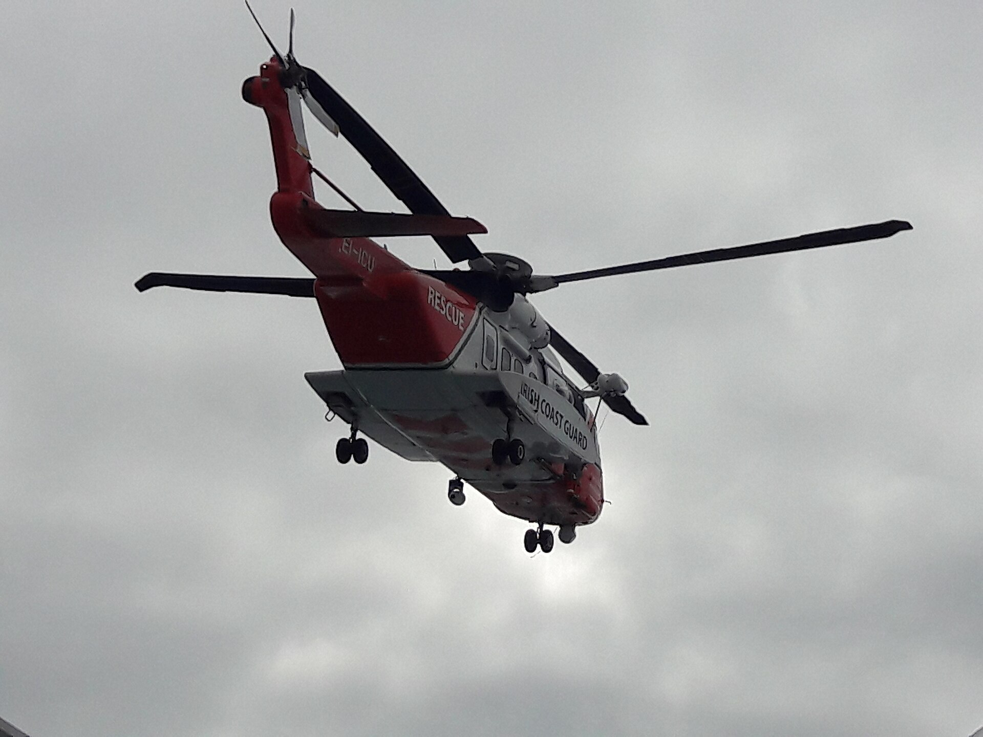 Irish Coast Guard helicopter hovering beside a ferry during an exercise.